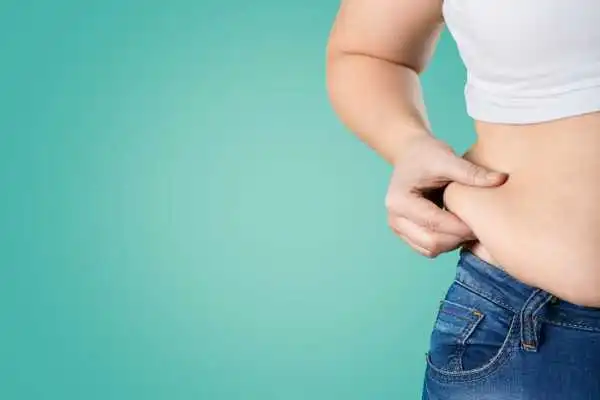 Image of woman pinching her love handles to show weight gain Rowley Regis